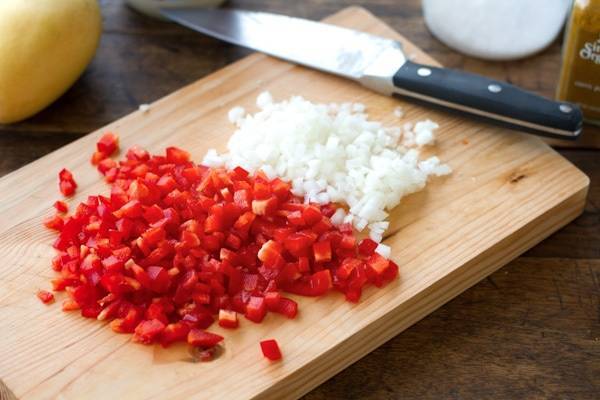 Peppers and onions on a cutting board.