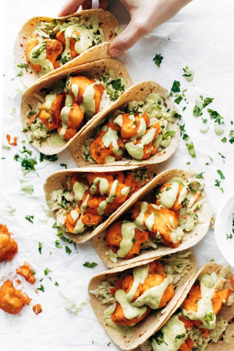 Buffalo Cauliflower Tacos on table in a row.