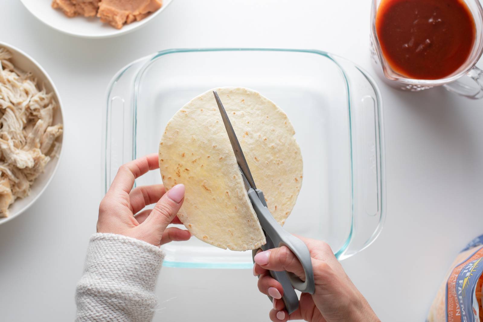 Cutting tortillas with a scissors.