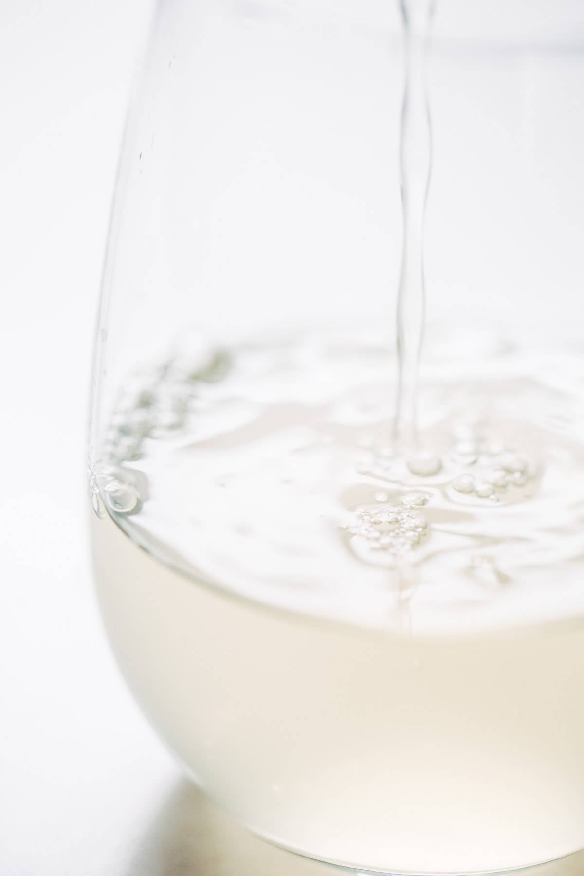 Clear liquid pouring into a glass.